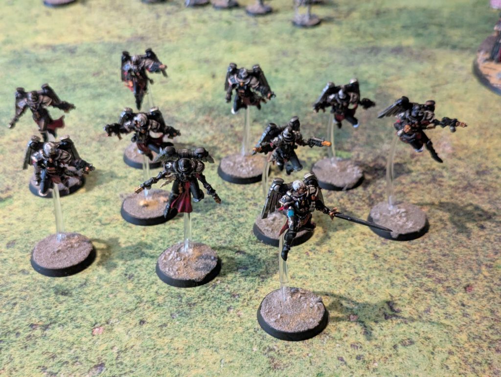 Ten painted Seraphim with twin pistols and jump packs, viewed from elevated front angle showing flight poses.