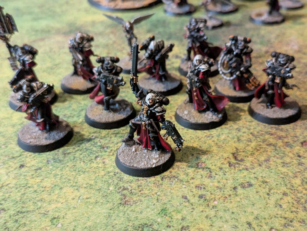Ten painted Battle Sisters with bolters from Adepta Sororitas, arranged in formation, top-front view.