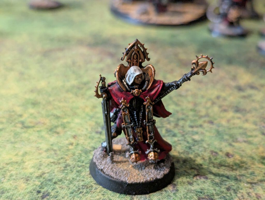 Painted Canoness with power sword and relic pistol, top-front angle on textured base.