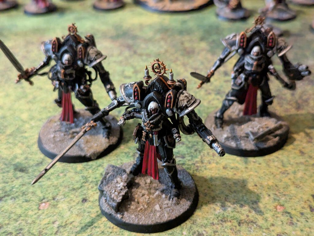 Three painted Paragon Warsuits with heavy weapons, top-front view showing armor reflections and squad formation.