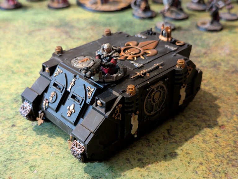 Painted Sororitas Rhino transport with insignia and weathering, viewed from top-front angle.