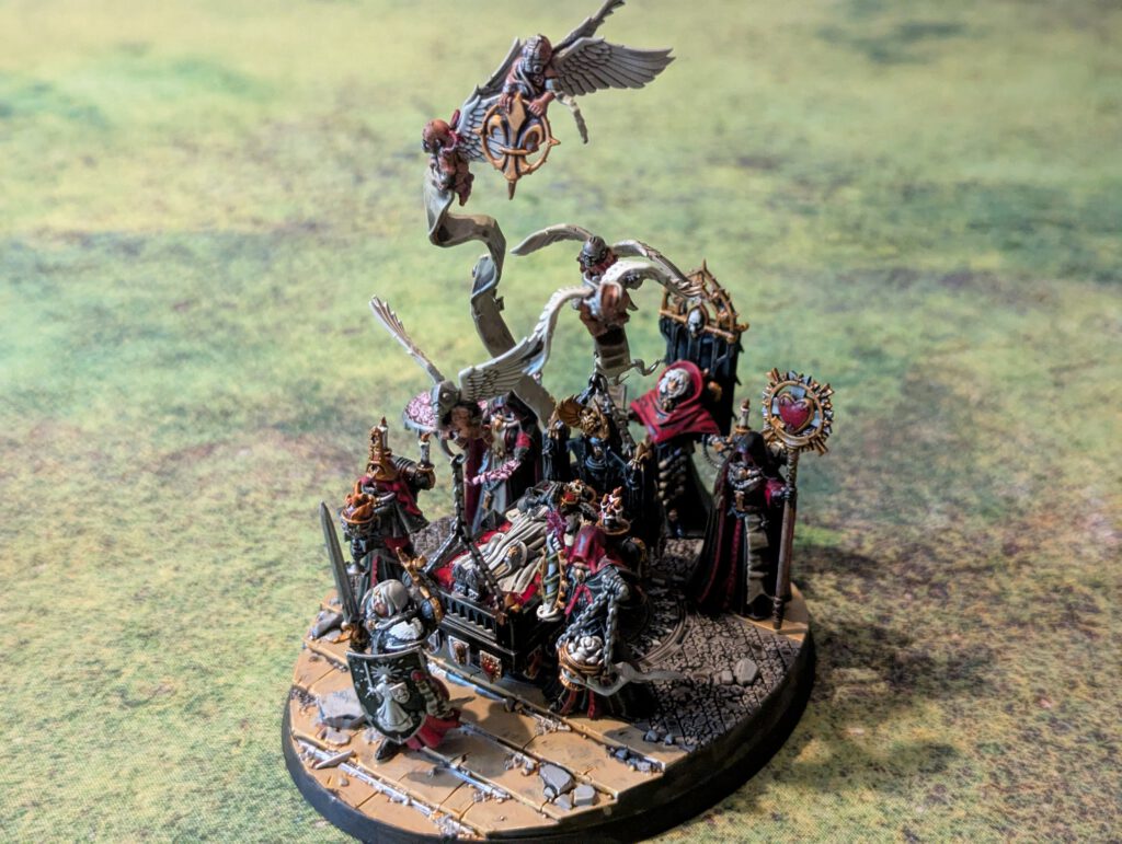 Painted Triumph of Saint Katherine centerpiece with attendants from Adepta Sororitas army, top-front view showing full display base.