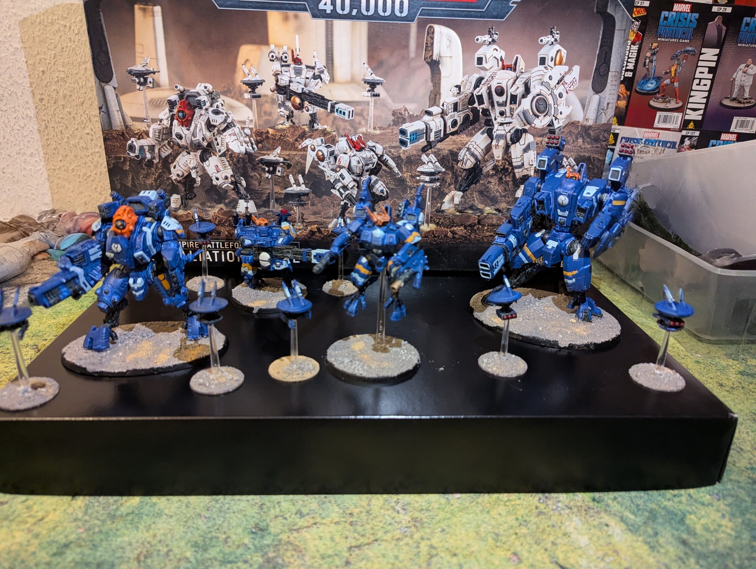 Painted T’au Retaliation Cadre Battleforce displayed together, including Commander, Broadside, Riptide, and Ghostkeel, viewed from a top-front angle.