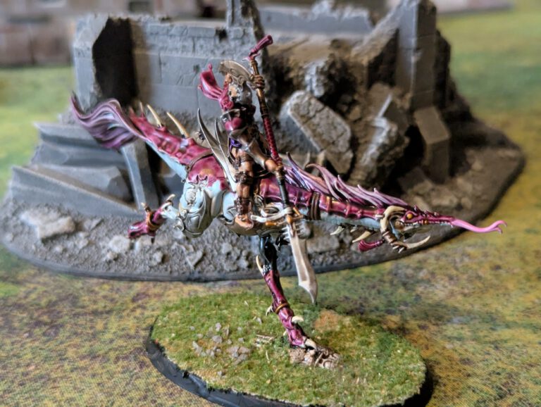 Painted Slickblade Seeker leaning forward in a charging pose, viewed from top-front angle.