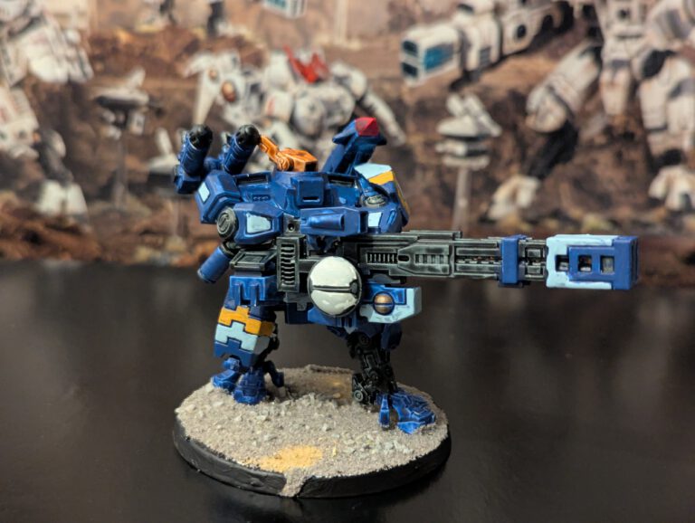 Painted T’au Broadside Battlesuit with heavy armaments, viewed from a slightly elevated front angle.