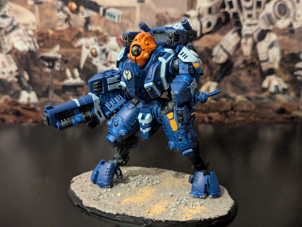 Painted T’au Ghostkeel Battlesuit with stealth drone details, viewed from a top-front angle.