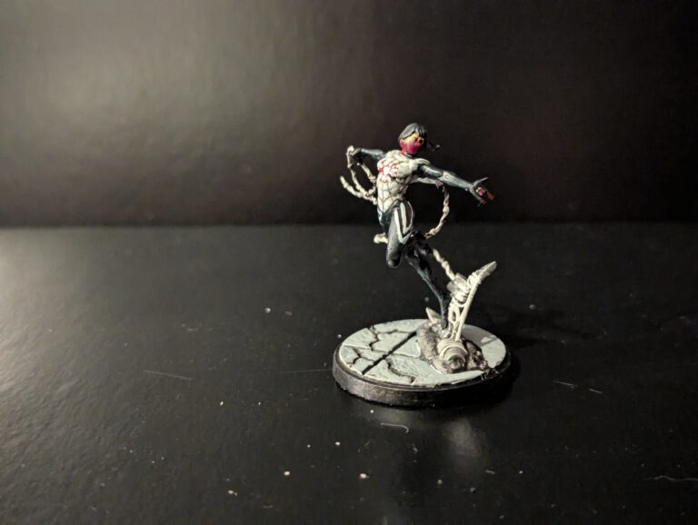 Painted Silk miniature from Marvel Crisis Protocol, viewed from a top-front angle showing flowing web lines and costume details.