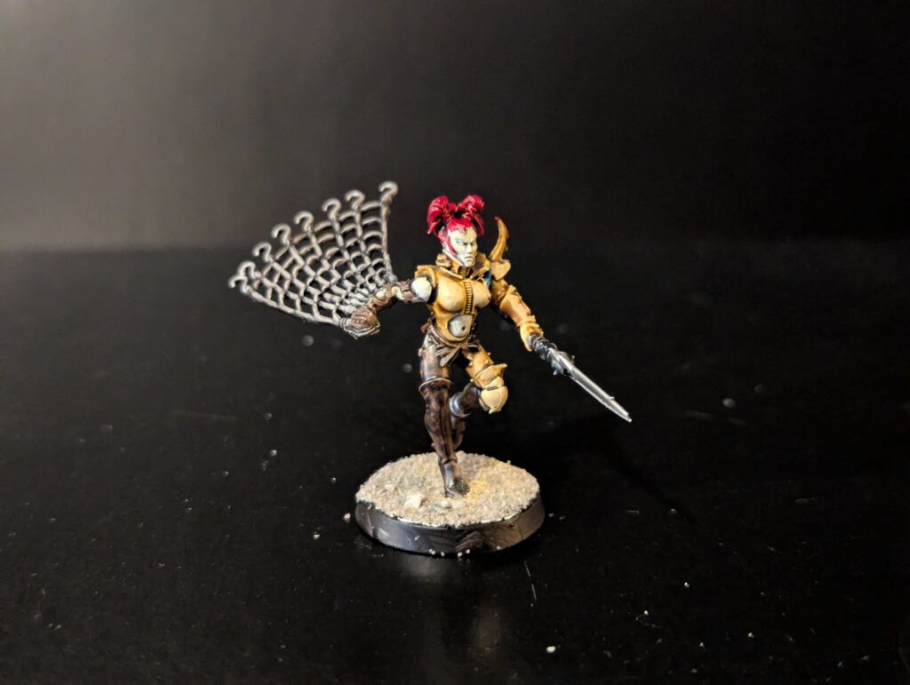 Painted Wych in acrobatic combat pose, viewed from a front angle.