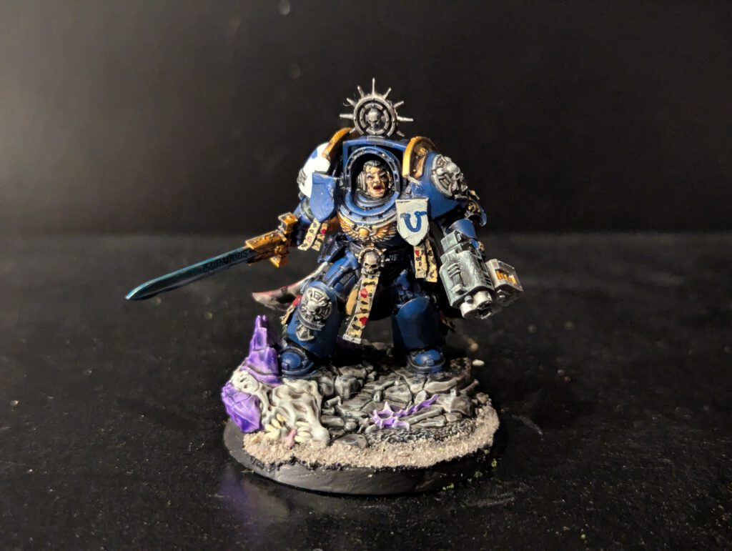Space Marine Captain in Terminator Armor miniature from Combat Patrol Magazine 1, painted in blue with white details, wielding a power sword, posed on a scenic base.