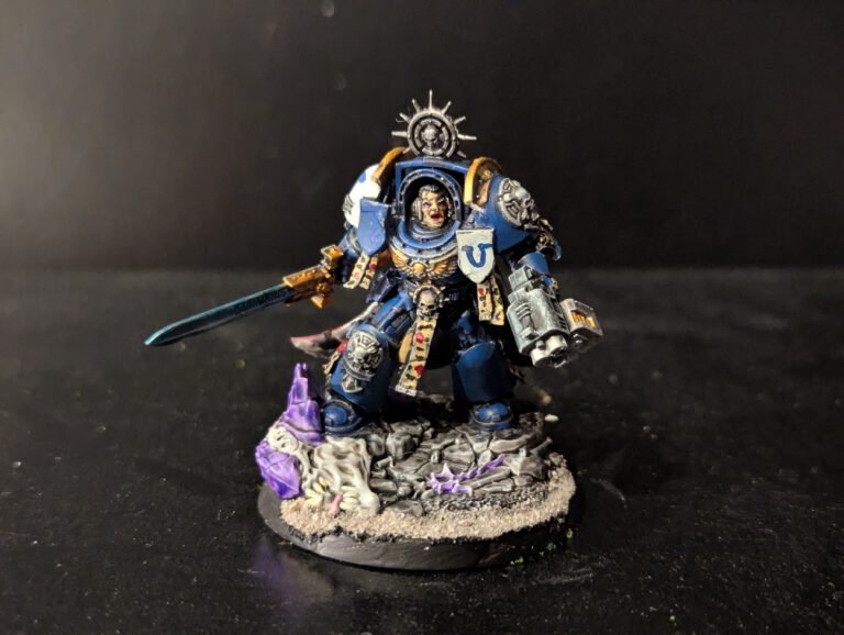 Space Marine Captain in Terminator Armor miniature from Combat Patrol Magazine 1, painted in blue with white details, wielding a power sword, posed on a scenic base.