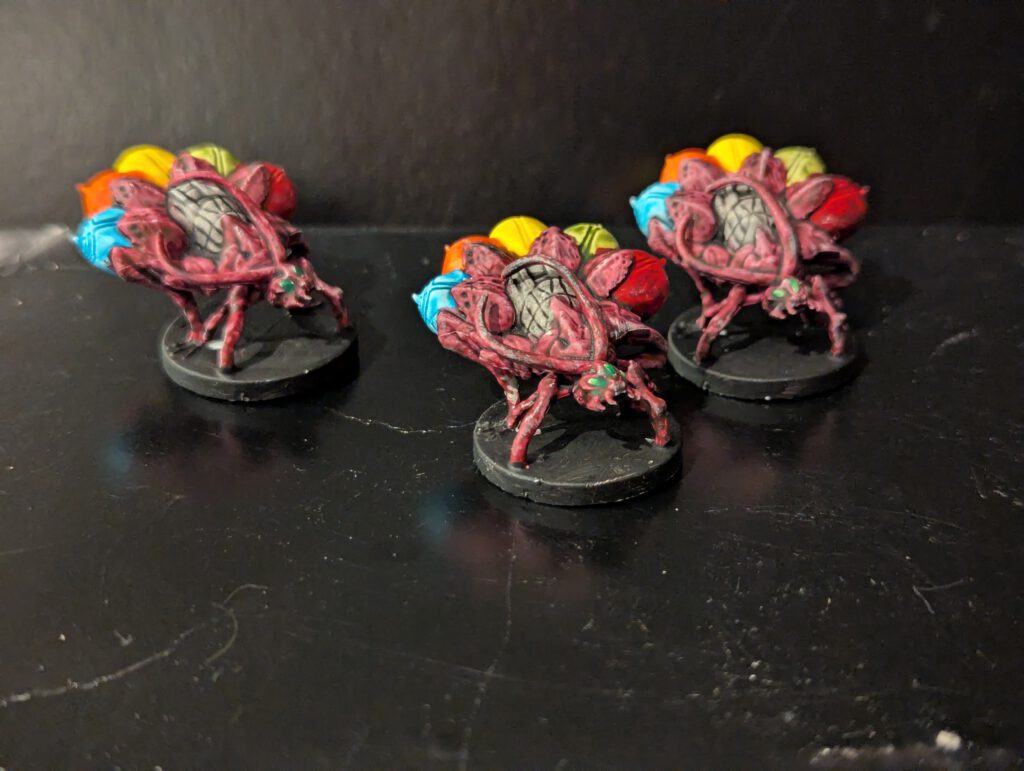 Three Fragor monsters painted with explosive orange and yellow energy effects.