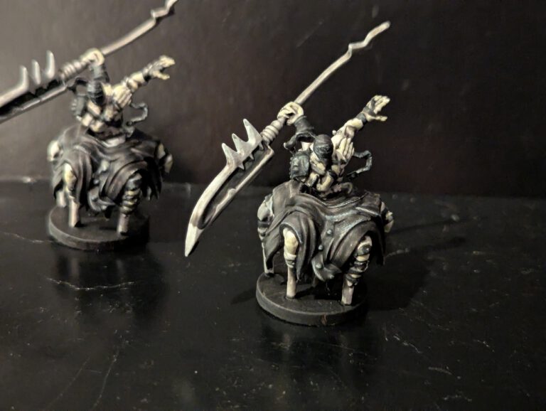 Two Tortured Immortal miniatures showing off the grisly muscle detail and dark, weathered armor.