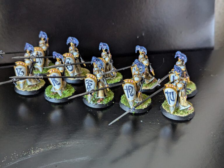 A unit of 10 painted Auralan Wardens with long spears and blue-trimmed shields in a defensive phalanx formation.