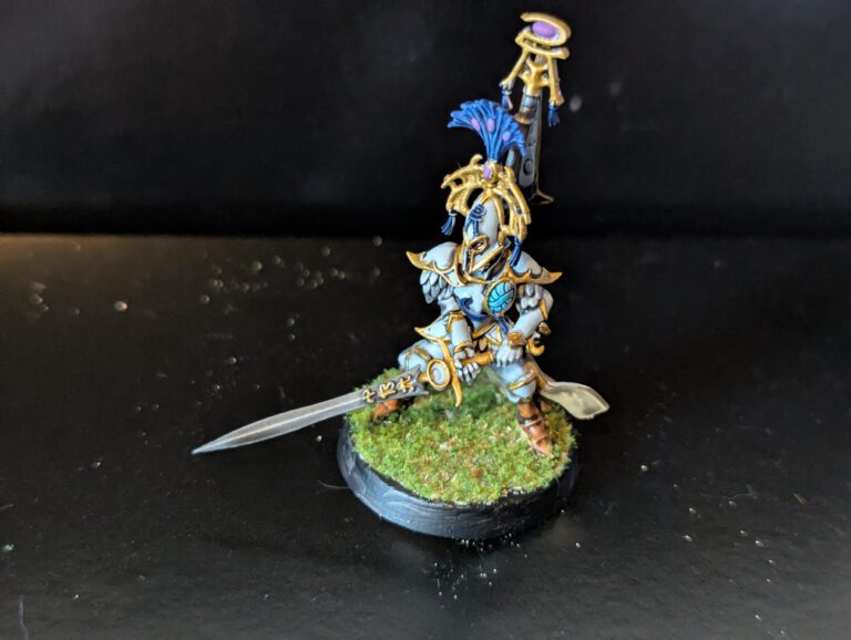 Detailed view of a Bladelord miniature focusing on the blue fabric textures and the ornate back-banner detail.