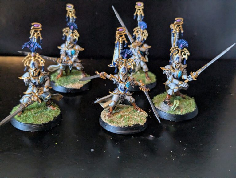 Five Vanari Bladelords with greatswords, featuring white armor and tall blue plumes on themed bases.