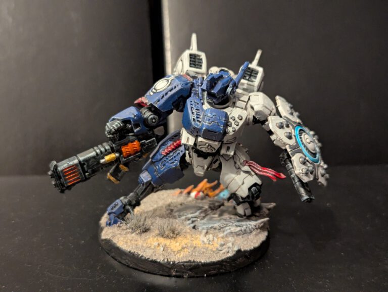Front view of a painted T'au Twin lance Battlesuit showing the torso detailing and weapon systems.