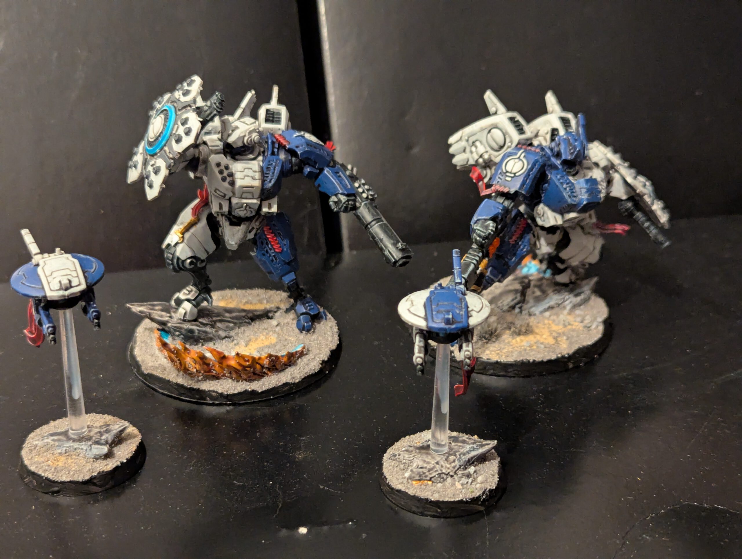 A fully painted T'au Empire Twin Lance featuring two Battlesuits and two Tactical Drones in a custom color scheme.