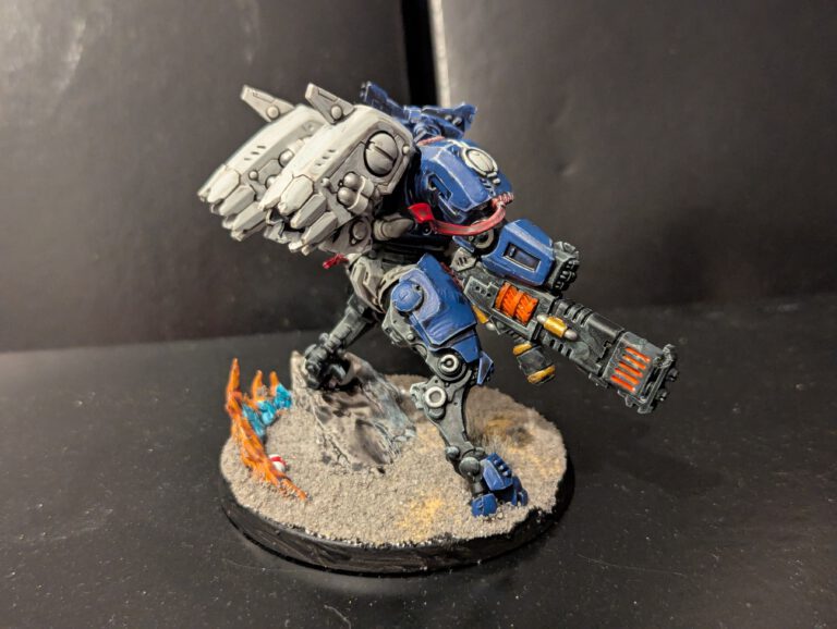 Rear view of a T'au Twin Lance suit showing the painted engine exhausts and back plating.