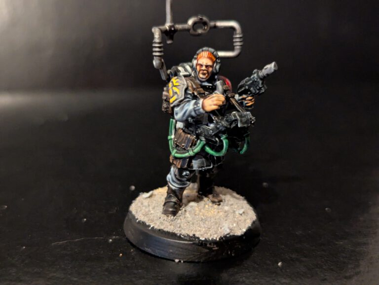 Imperial Guard veteran barking orders into a handset with a master-vox communication array strapped to his back.
