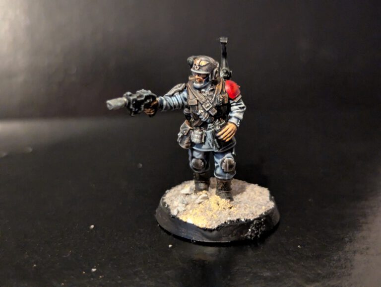 Cadian squad medic holding Pistol and medical kit, featuring clean armor plates with red cross insignia.