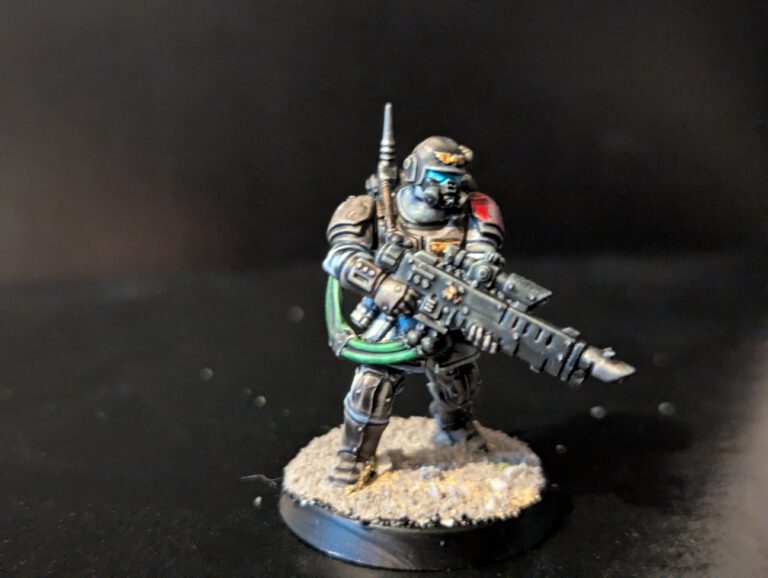 Fully painted Kasrkin special forces model standing in a tactical stance on a muddy battlefield base.